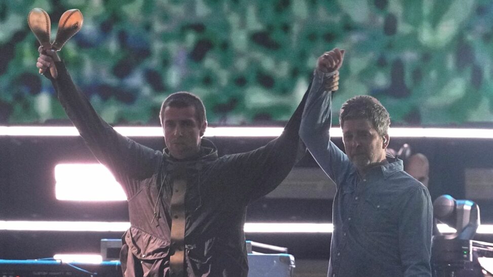 Gallagher brothers share a high five and hug as oasis reunite on stage after 16 years